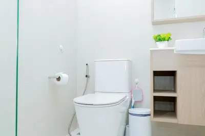 a white bathroom with a toilet and a sink at Laguna Skypark BangTao beach Phuket in Ban Thalat Choeng Thale