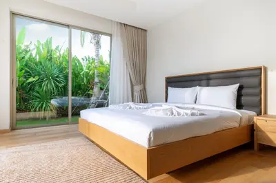 a bedroom with a large bed and a large window at Trichada Tropical - 3 Bedrooms Pool Villa in Laguna Phuket