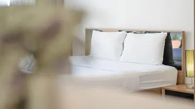 a bedroom with a bed with white sheets and pillows at Mountain Loft 700m from Beach [Pool & Gym] in Karon Beach