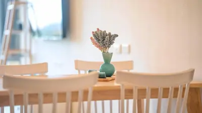 a table with chairs and a vase with flowers in it at SeaView 1BR Apartment at Karon Beach in Karon Beach