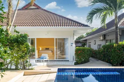 a house with a swimming pool in front of a house at Loft with pool - 8min walk to Rawai Beach - 