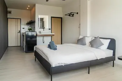 a bedroom with a large bed and a kitchen at Quiet & Comfy studio near Rawai Beach - 
