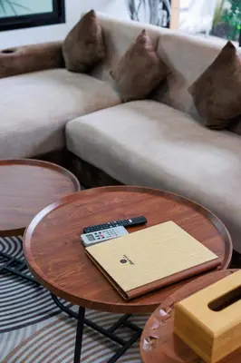 a coffee table with a remote control on top of it at La Ferme Villa - Modern 3 Bedrooms with Private Pool in Rawai Beach