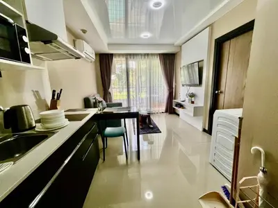 a kitchen with a sink and a table in a room at Cozy Condotel Maikhao in Mai Khao Beach