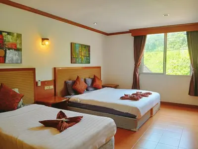 a hotel room with two beds and a window at Haweli Restaurant & Guest House in Ao Nang Beach