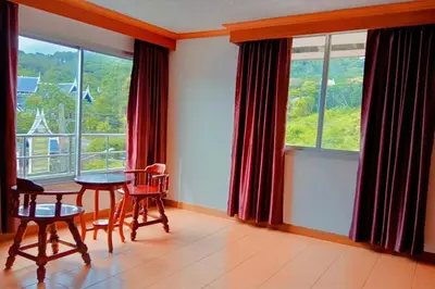 a dining room with a table and chairs and windows at Haweli Restaurant & Guest House in Ao Nang Beach