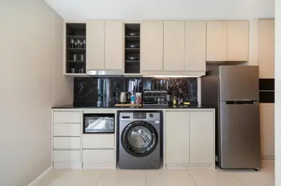 a kitchen with a washing machine and a refrigerator at Deluxe Surin apartment with washer and fast WIFI in Surin Beach