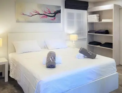 a bedroom with a white bed with shoes on it at Karon beach Stylish large 2BR with Sea View in Karon Beach