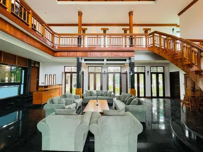 a living room with couches and a wooden staircase at Kiri Anda Villa Phuket in Rawai Beach