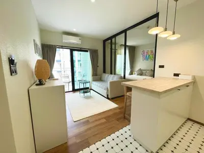 a kitchen and living room with a table and a couch at Title HALO 1 - Modern 1BR Pool View Walk to Nai Yang Beach in Nai Yang Beach