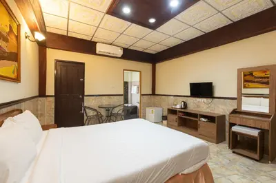 a hotel room with a bed and a tv at Kata Palace Phuket Hotel in Kata Beach