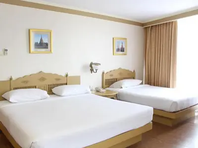 two beds in a hotel room with white sheets at Neptuna Kata Beach in Kata Beach