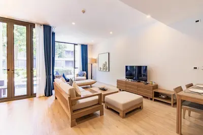 a living room with a couch and a tv at Baan Mai Khao beachfront apartments in Mai Khao Beach