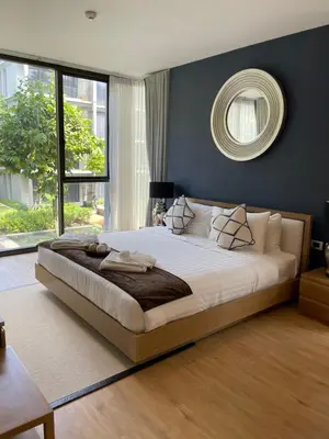 a bedroom with a large bed with a mirror on the wall at Baan Mai Khao beachfront apartments in Mai Khao Beach
