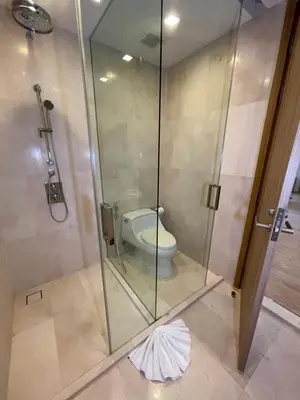 a bathroom with a glass shower with a toilet at Baan Mai Khao beachfront apartments in Mai Khao Beach