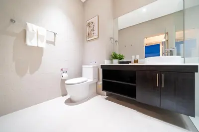 a white bathroom with a toilet and a sink at The bay Cape Yamu Villa 10 in Phuket Town