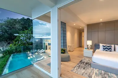 a bedroom with a bed and a large glass window at Villa ANDA in Kamala Beach