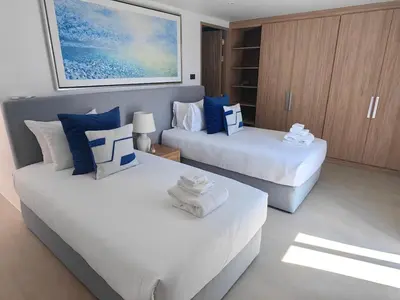 two beds in a room with blue and white at The bay Cape Yamu Villa 2 in Ko Lek