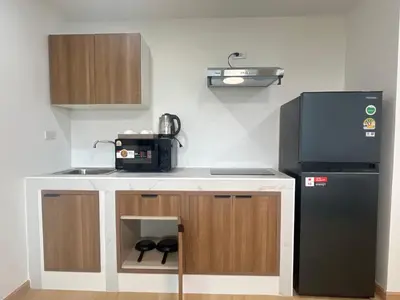 a small kitchen with a black refrigerator and a sink at Hill Bay Suites Hotel in Patong Beach