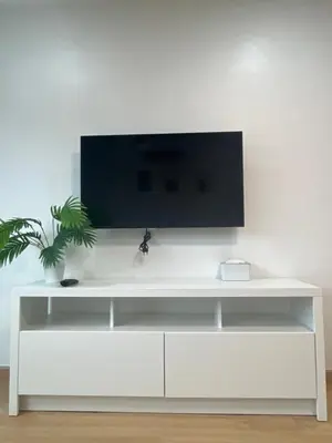 a white entertainment center with a tv on a white wall at Hill Bay Suites Hotel in Patong Beach