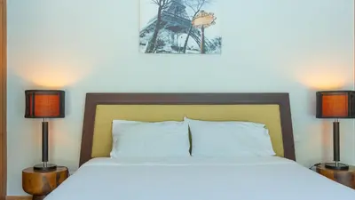 a bedroom with a bed with two lamps and a tower at Bangtao Beach 3 bedroom private pool villa in a quiet area near Boat Avenue mono wings in Bang Tao Beach