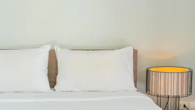 a white bed with two pillows and two tables at Bangtao Beach 3 bedroom private pool villa in a quiet area near Boat Avenue mono wings in Bang Tao Beach
