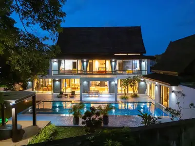 a house with a swimming pool at night at Bang Tao 6-bedroom large private pool modern Balinese style leisure holiday villa BBQ family group the park in Bang Tao Beach