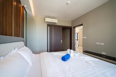 a large white bed with a blue object on it at Surin Beach Serviced 3 Bedroom Sea View Apart-ment Comprehensive Facilities Resort Pool Gym Guest Choice in Surin Beach