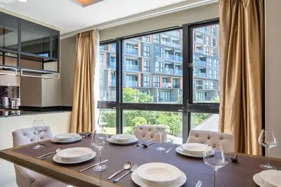 a dining room table with chairs and a large window at Surin Beach Serviced 3 Bedroom Sea View Apart-ment Comprehensive Facilities Resort Pool Gym Guest Choice in Surin Beach