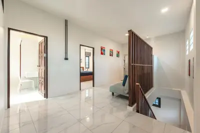 a living room with a staircase and a room with a couch at Areca Holiday Villa 3, Naiharn Beach in Rawai Beach