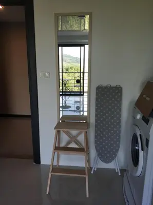 a room with a stool and a washing machine at Nature View Residence in Ban Mai Salae