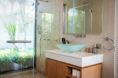 a bathroom with a sink and a glass shower at BangTao Anchan \u8c6a\u534e\u4e24\u5367 \u79c1\u4eba\u6cf3\u6c60 \u73b0\u4ee3\u5ea6\u5047\u5df4\u5398\u98ce in Layan Beach