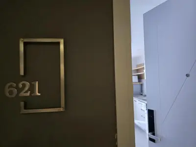 a door to a kitchen with a clock on the wall at Sea Side Haven 1 Bed T2-621 in Phuket Town