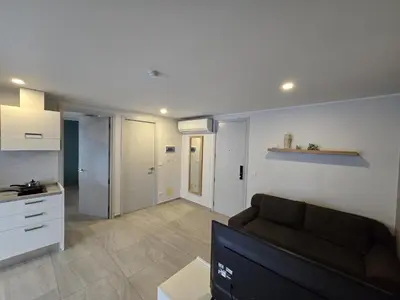 a living room with a couch and a kitchen at Sea Side Haven 1 Bed T2-621 in Phuket Town