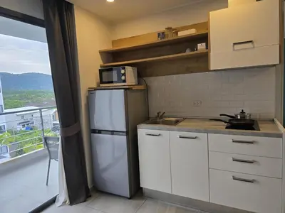 a kitchen with a white refrigerator and a balcony at Sea Side Haven 1 Bed T2-621 in Phuket Town