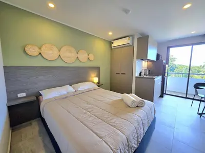 a bedroom with a large bed with wooden plates on the wall at Island Drift Studio T3-332 in Chalong