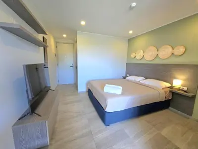 a bedroom with a bed and a flat screen tv at Island Drift Studio T3-332 in Chalong
