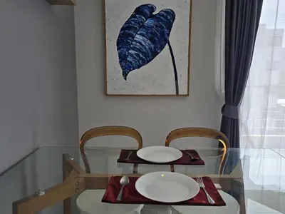 a glass table with two chairs and a blue feather painting at Skyline Serenity 1Bed T2-721 in Phuket Town