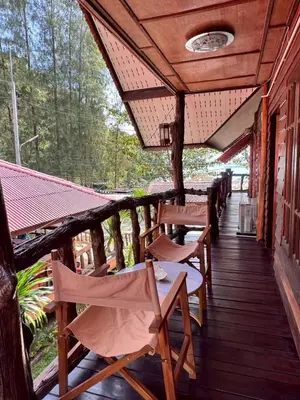 a deck with chairs and tables on a house at Bangalow Coconut corner in Ban Laem Sai