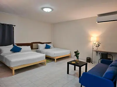 a hotel room with two beds and a couch at Friends Retreat - Phuket Airport in Ban Bo Han
