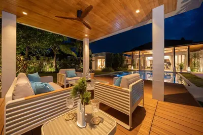 an outdoor patio with couches and a table and chairs at Luxury 4BR Pool Villa Botanica Bangtao Beach in Ban Thalat Choeng Thale