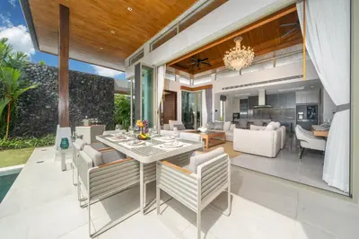 an open living room and dining room with a table and chairs at Luxury 4BR Pool Villa Botanica Bangtao Beach in Ban Thalat Choeng Thale