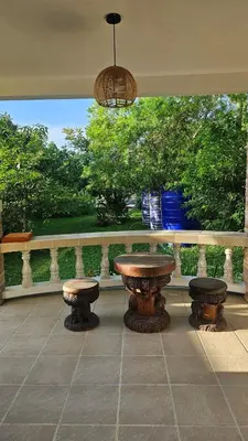 a patio with a table and two benches on a porch at Tropical 1BR Bungalow in Rawai with Shared Pool in Nai Harn Beach