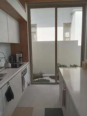 a kitchen with white counters and a large window at Luxury Design 3 Bedroom Villa AB2 in Phuket Town