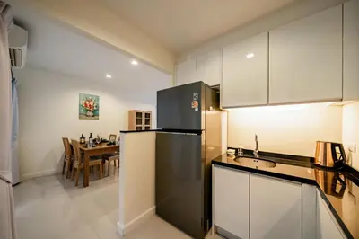a kitchen with a black refrigerator and a table at Townhouse in the very center of Laguna, 600 m from Bang Tao in Phuket