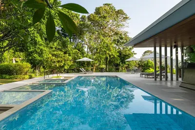 an outdoor swimming pool with blue water and trees at Villa Princess Maria in Kata Beach