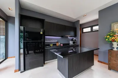 a kitchen with black cabinets and a black counter top at Villa Coco - Classy Modern 2 Bedroom Pool Villa in Ban Saiyuan (1)