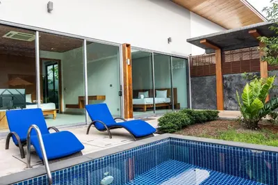 a patio with blue chairs and a swimming pool at Villa Coco - Classy Modern 2 Bedroom Pool Villa in Ban Saiyuan (1)