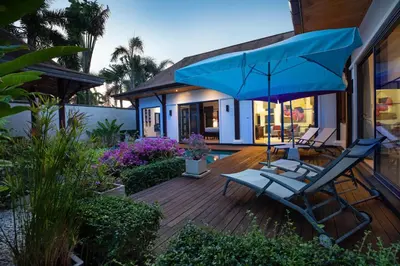 a deck with two chairs and a blue umbrella at Villa Dinadi - Superb 2 Bedrooms Pool Villa in Rawai Beach
