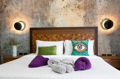 a bedroom with a bed with purple towels on it at Villa Matara - Large & Stylish 5 Bedrooms with Pool in Rawai Beach